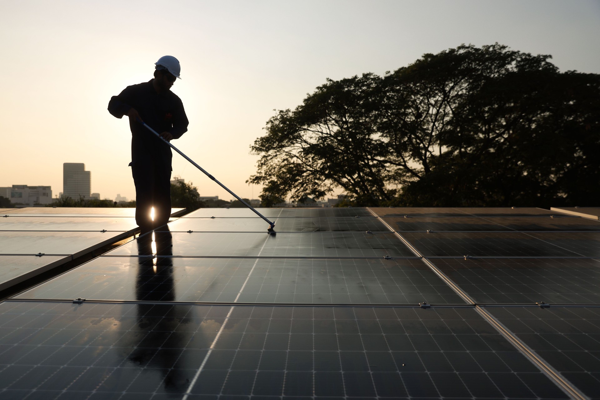 Cleaning solar panels with brush and water, Photovoltaic technicians were cleaning and washing the surface of the solar panels which had dust and birds' pooping